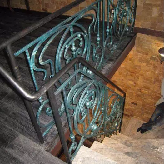 Black interior wrought iron stair railing with round iron handrail and green patina. 110